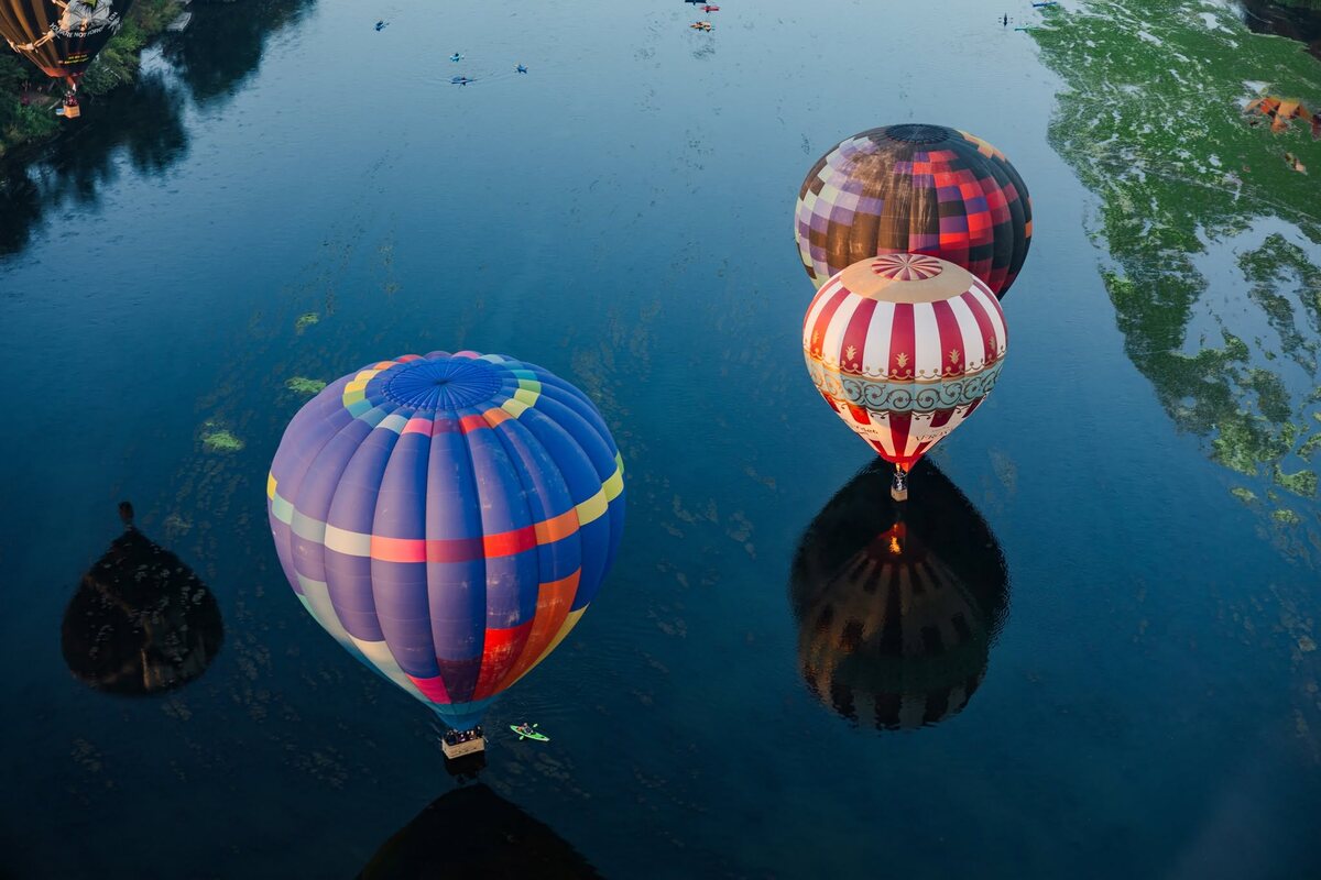 Hot air balloons reflected in calm water