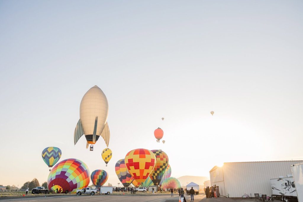Colorful hot air balloons inflating on the field as the sun rises