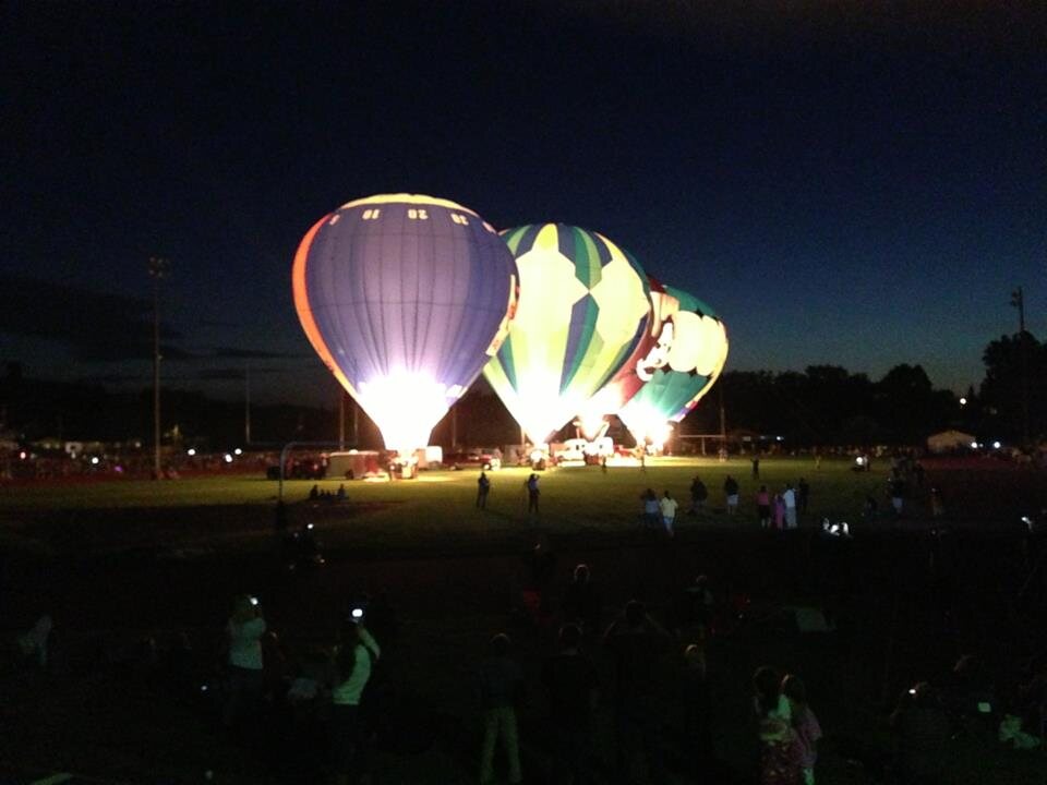 Balloons illuminated against a dark sky during Night Glow
