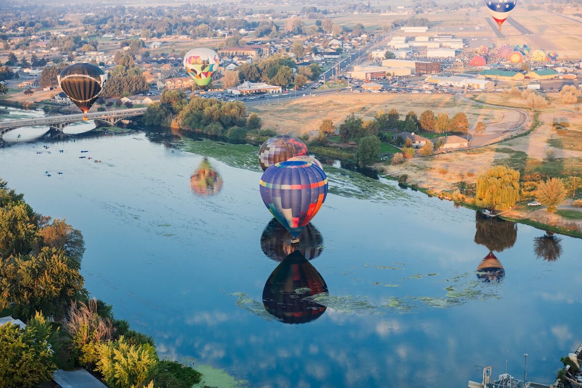 Hot air balloons floating above the Yakima River and Prosser landscape