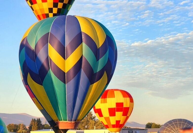 Spectator photographing colorful balloons at launch