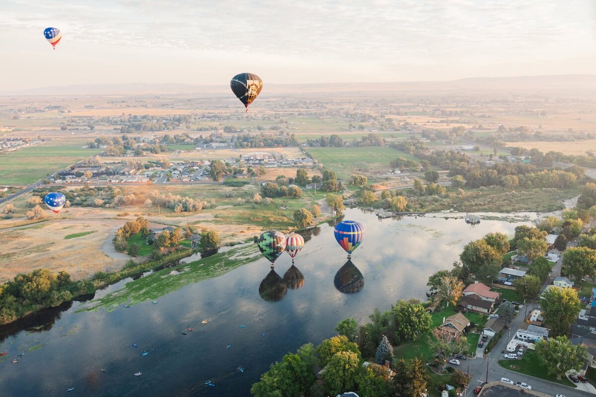 Hot air balloons floating above the Yakima River and Prosser valley at dawn